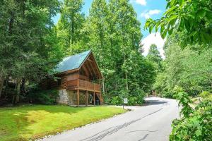 a log cabin on a road next to a road at Yeti Lodge by Avada Properties in Gatlinburg