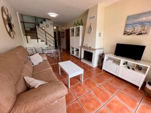 ein Wohnzimmer mit Sofa und Fernseher in der Unterkunft Casa Verdemar Golf Islantilla in Islantilla