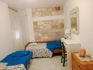 una camera da letto con due letti e un muro di pietra di Appartamento bilocale ERICA a Monteriggioni