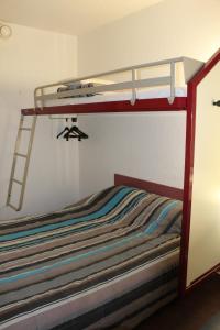 ein Schlafzimmer mit einem Etagenbett mit einer Leiter in der Unterkunft hotelF1 Saint-Die in Saint Die