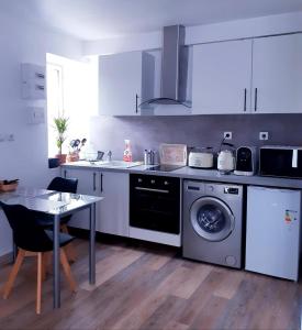 a kitchen with a washing machine and a table at Studio Paisible in Gien-sur-Cure +14 photos
