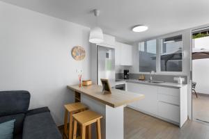 Una cocina y una sala de estar con una mesa y un sofá. en ENEXO BEACH HOUSE, en San Bartolomé