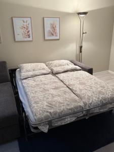 a bed in a bedroom with a lamp and pictures on the wall at Stor attraktiv studioleilighet i sentrum in Trondheim