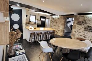 Una cocina con una mesa y taburetes en una habitación. en Gite le Parveau, 3 étoiles meublé de tourisme, en La Guiltière