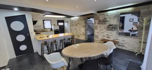 Una habitación con una mesa y sillas y una cocina. en Gite le Parveau, 3 étoiles meublé de tourisme, en La Guiltière