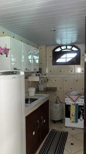a kitchen with a sink and a refrigerator in it at Wonders of Arraial Loft 2 in Arraial do Cabo +5 photos