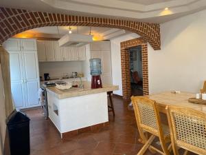 a kitchen with a counter and a table with chairs at Casa Rosales in Antigua Guatemala