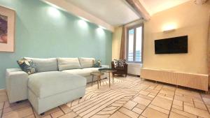ein Wohnzimmer mit Sofa und Fernseher in der Unterkunft Proche du Cours Saleya et de la plage, dans le vieux Nice, spacieux et climatisé in Nizza