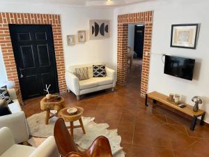 a living room with a couch and a tv at Casa Rosales in Antigua Guatemala