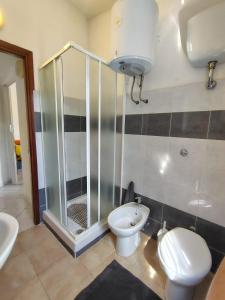 a bathroom with a shower and a toilet and a sink at Il Nido 1 di San Pietro in Budoni +13 photos