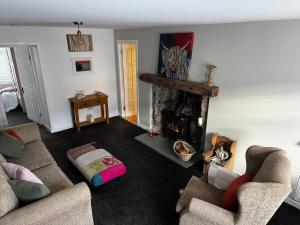 a living room with two couches and a fireplace at Cosy Wee Cottage in Monkton +8 photos