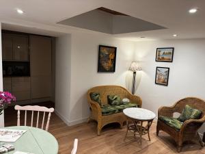 a living room with two chairs and a table at Cosy Wee Cottage in Monkton