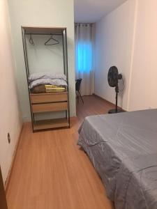 ein Schlafzimmer mit einem Spiegel und einem Bett darin in der Unterkunft Apartamento aconchegante no centro de São Lourenço 700m do Parque das Águas in São Lourenço