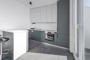 a kitchen with white cabinets and a stove top oven at Mokos Modern Suite with Sea View and Jacuzzi in Dubrovnik