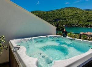 a hot tub on a balcony with a view of the water at Mokos Modern Suite with Sea View and Jacuzzi in Dubrovnik