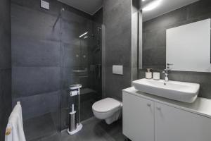 a bathroom with a white sink and a toilet at Mokos Modern Suite with Sea View and Jacuzzi in Dubrovnik