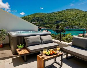 a patio with a hot tub and a table with wine glasses at Mokos Modern Suite with Sea View and Jacuzzi in Dubrovnik