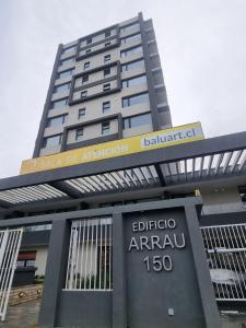 a tall building with a sign in front of it at Departamento moderno y central en Chillan in Chillán