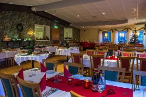 a restaurant with white tables and chairs with christmas decorations at Lungsunds Hotell & Camping in Storfors