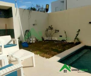 a backyard with a swimming pool and a white fence at Green Hôte in Gammarth