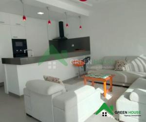 a living room with two white couches and a table at Green Hôte in Gammarth +2 photos