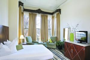 a hotel room with a bed and a television at The Mansion on Delaware Avenue in Buffalo
