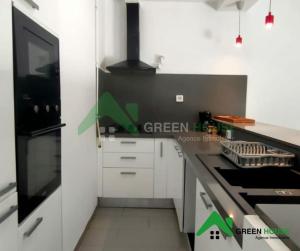 a kitchen with white cabinets and a black stove top oven at Green Hôte in Gammarth