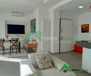 a living room with a white couch and a table at Green Hôte in Gammarth