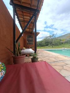 a patio with a table and a pool at Chalés Vale Encantado -Serra do Cipó- in Jaboticatubas