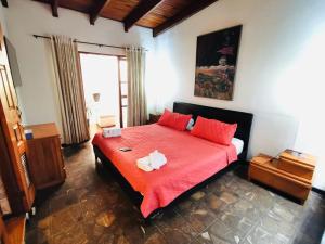 a bedroom with a red bed with red pillows at Colours Oasis Resort ADULT ONLY in San José