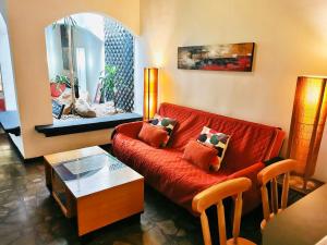 a living room with a red couch and a mirror at Colours Oasis Resort ADULT ONLY in San José