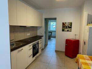 a kitchen with white cabinets and a red refrigerator at Felsenblick in Pforzheim