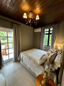 una camera da letto con un letto e un soffitto in legno di Casas Petite Province Tiradentes refúgio ao pé da Serra a Tiradentes