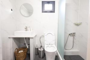 a white bathroom with a toilet and a sink at Paradise Lofts in Asprovalta +29 photos