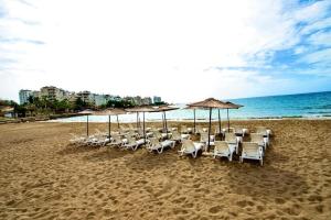 a group of chairs and umbrellas on a beach at Palm Beach Hotel in Silifke