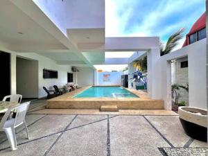 a house with a swimming pool in the middle at Suites Sol Nuevo in Rincon de Guayabitos