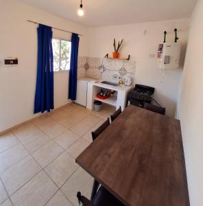 a dining room with a table and a kitchen at Departamentos Reinoso in Fiambala