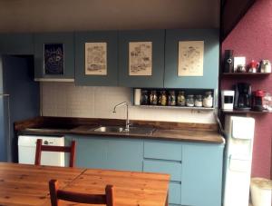 a kitchen with a table and a sink and a refrigerator at L'isola Guesthouse in Heybeliada