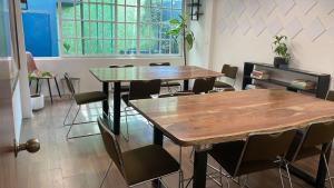 two tables and chairs in a room with a window at Uotan in Mexico City