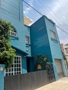 a blue building with a sign in front of it at Uotan in Mexico City