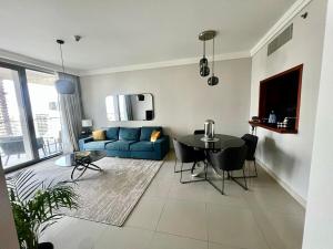 a living room with a blue couch and a table at Elegant apartment Dubai downtown in Dubai