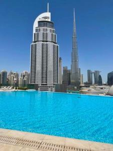 a large blue swimming pool in front of a city at Elegant apartment Dubai downtown in Dubai