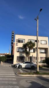 a white car parked in front of a building at Hotel Rook INN in Paipa