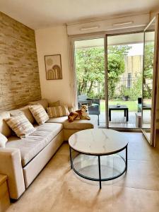 a living room with a couch and a table at Temple Luxe- Balnéo et Jardin, wifi, parking privé securisé in Béziers