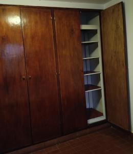 einen Schrank mit Holzschränken in einem Zimmer in der Unterkunft Departamento en planta alta in Salta