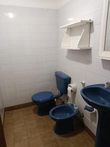 ein Badezimmer mit einem blauen WC und einem Waschbecken in der Unterkunft Departamento en planta alta in Salta