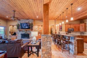 a living room with a bar and a stone fireplace at Birds Nest on Sugar Mountain in Sugar Mountain