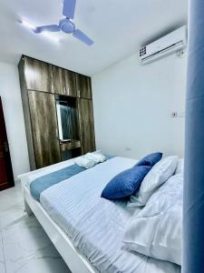 モンバサにあるHarmony 1 Bedroom Apartmentの青い枕が付いた大きなベッドのある寝室