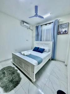 モンバサにあるHarmony 1 Bedroom Apartmentの青い枕と窓のあるベッドのある寝室