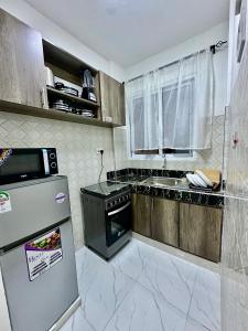 モンバサにあるHarmony 1 Bedroom Apartmentの小さなキッチン(コンロ、冷蔵庫付)